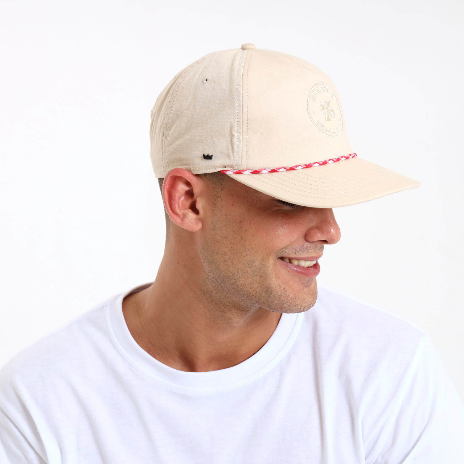 Man wearing a beige cap with a self colour Breazies Beach Club logo embroidered on the front panel.