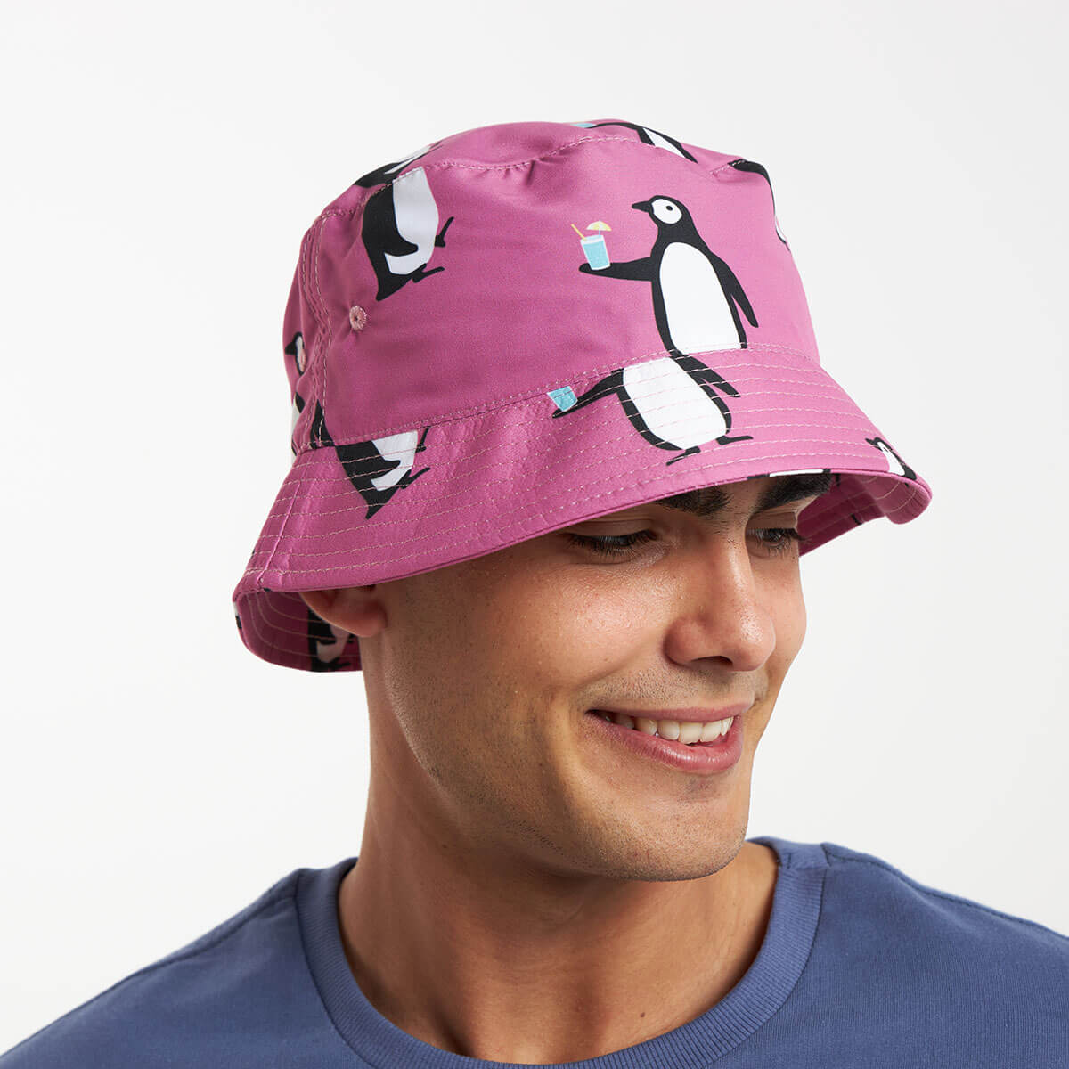 A male model wearing a purple bucket hat featuring a quirky penguin design.