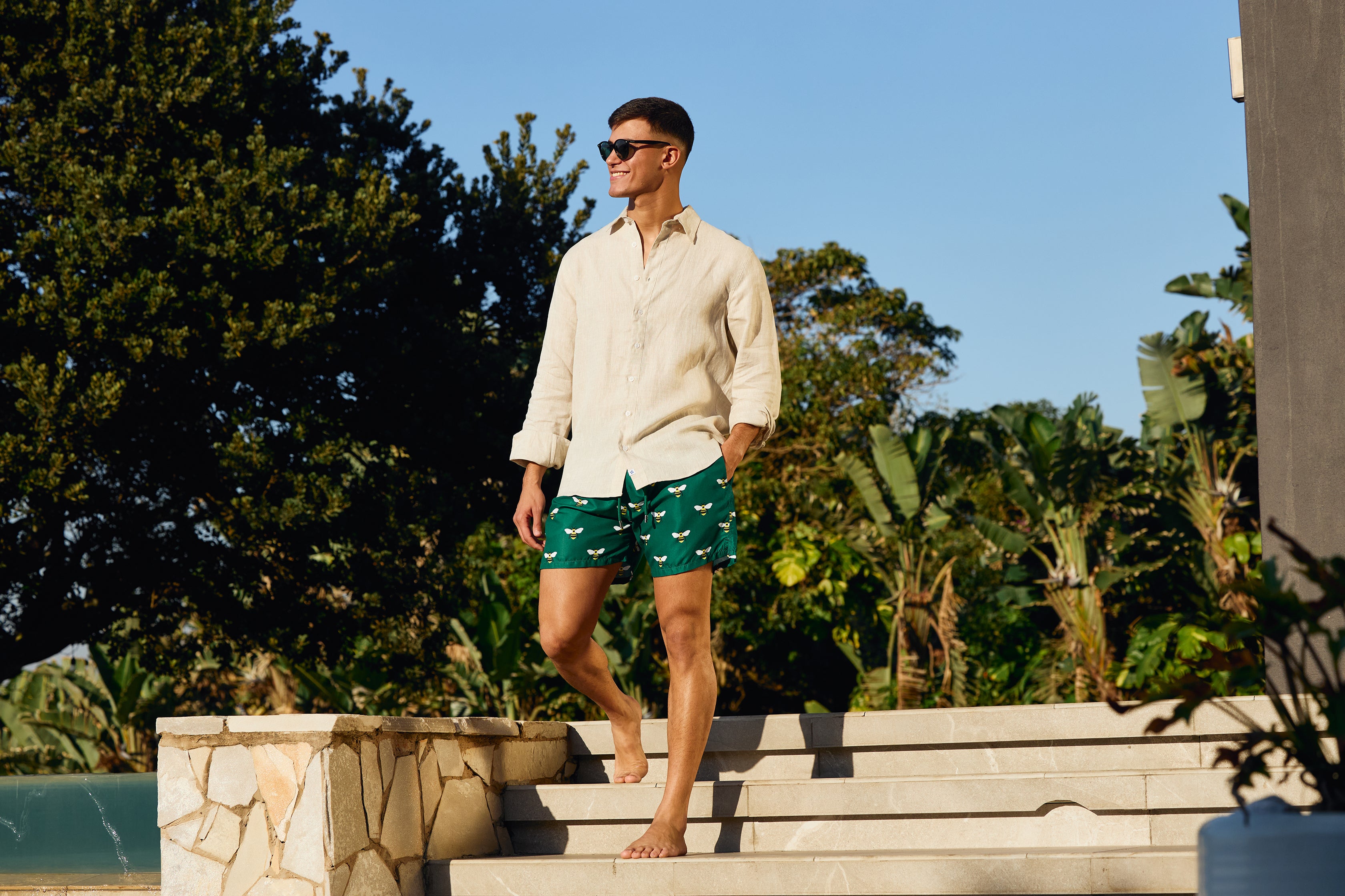 Man in a Natural Linen Shirt and Emerald Bee Swim shorts by Breazies