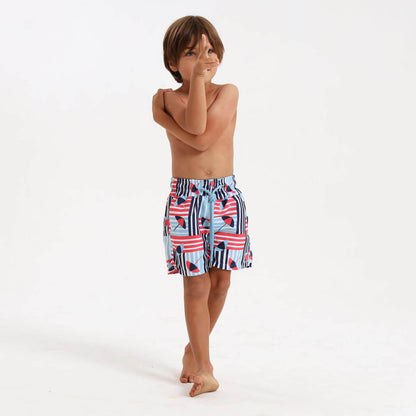Boy wearing fun swim shorts with a blue umbrella print.
