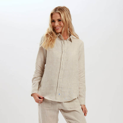 A woman wearing a beige long sleeve linen shirt with a classic button-down front and embossed Breazies trims.