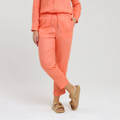 Long peach orange linen pants being worn by a female model.