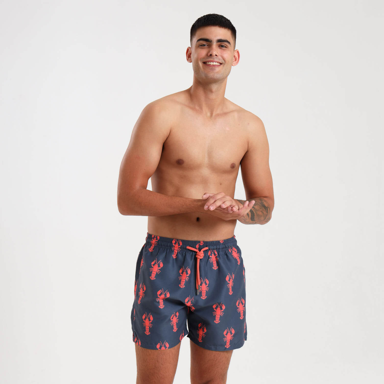 Man wearing steel swim shorts with an orange lobster pattern.