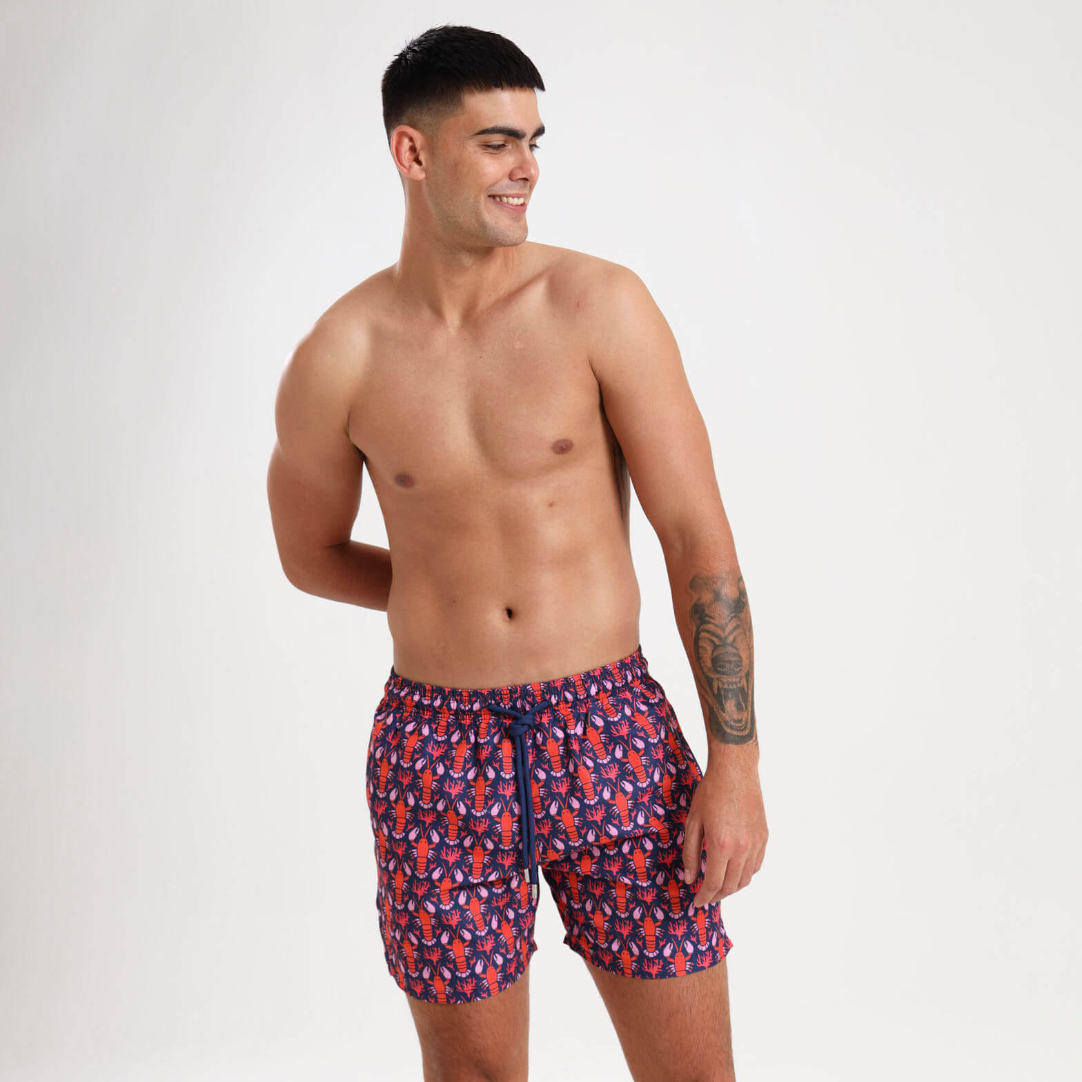 Mid length swim shorts for men with a navy and orange lobster pattern.