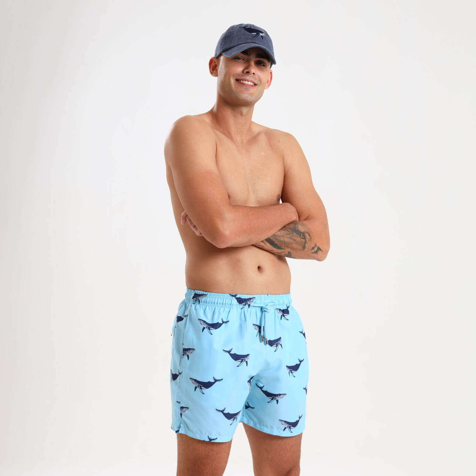 Light blue elasticated swim trunks for men with a whale design on them.