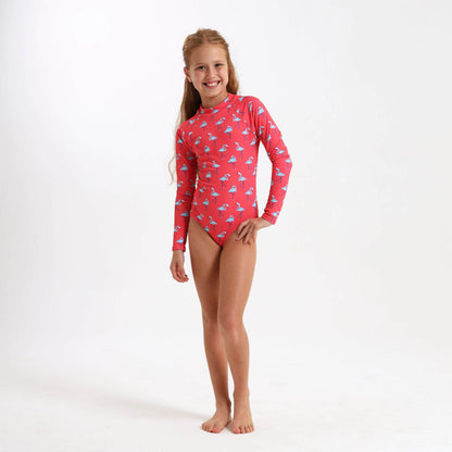 Young girl wearing a long sleeve swimsuit with a coral and blue flamingo print on it.