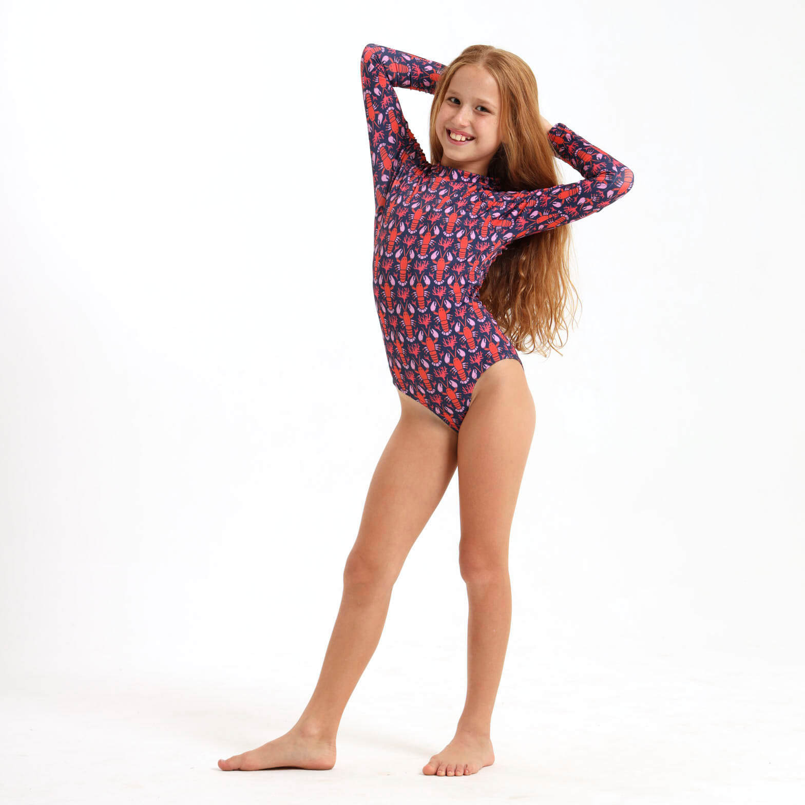 Girl wearing a navy long sleeve swimsuit featuring an orange lobster design.