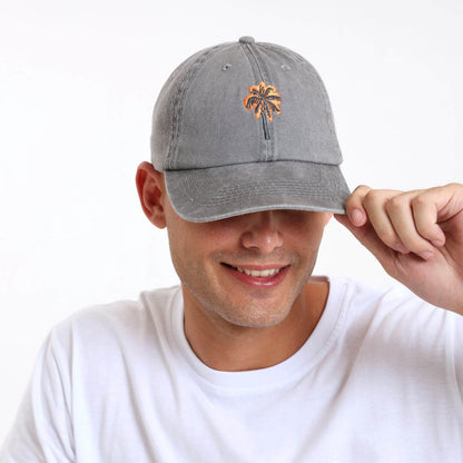 Man wearing a gray cap with a palm tree design on the front panel.