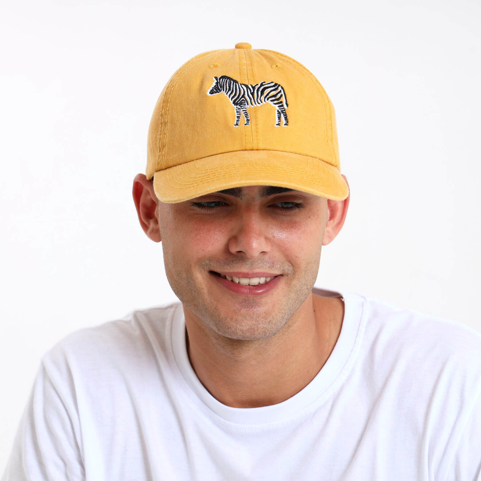 Man wearing a yellow cap with a black and white zebra design on the front.