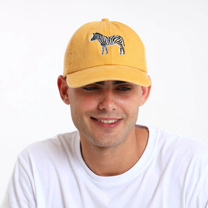 Man wearing a yellow cap with a black and white zebra design on the front.