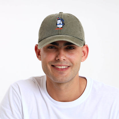 Man wearing an army green cap with a penguin design on the front panel.